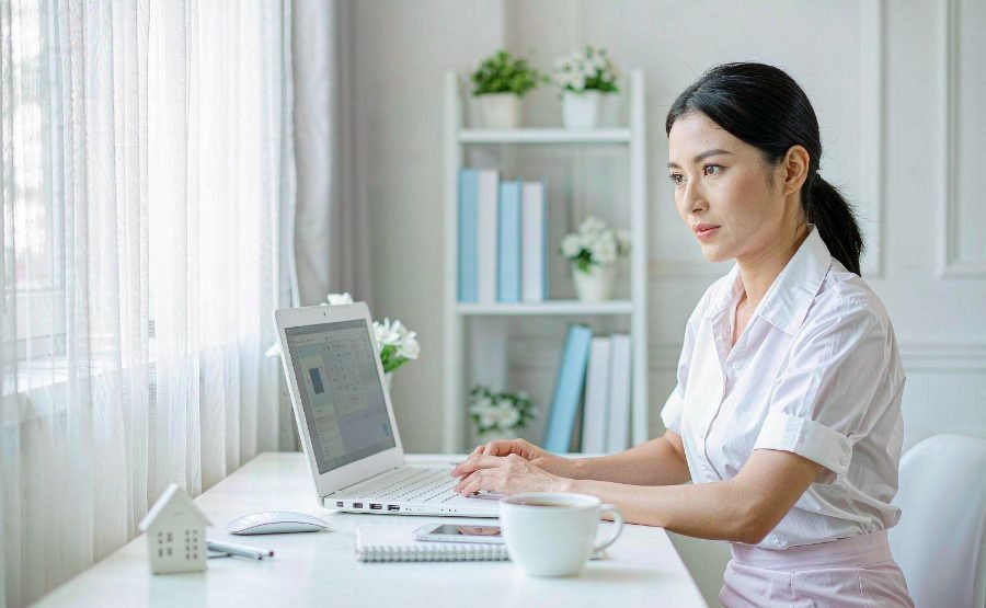 企业知识库场景：员工在办公桌前使用笔记本电脑与 AI 助手对话